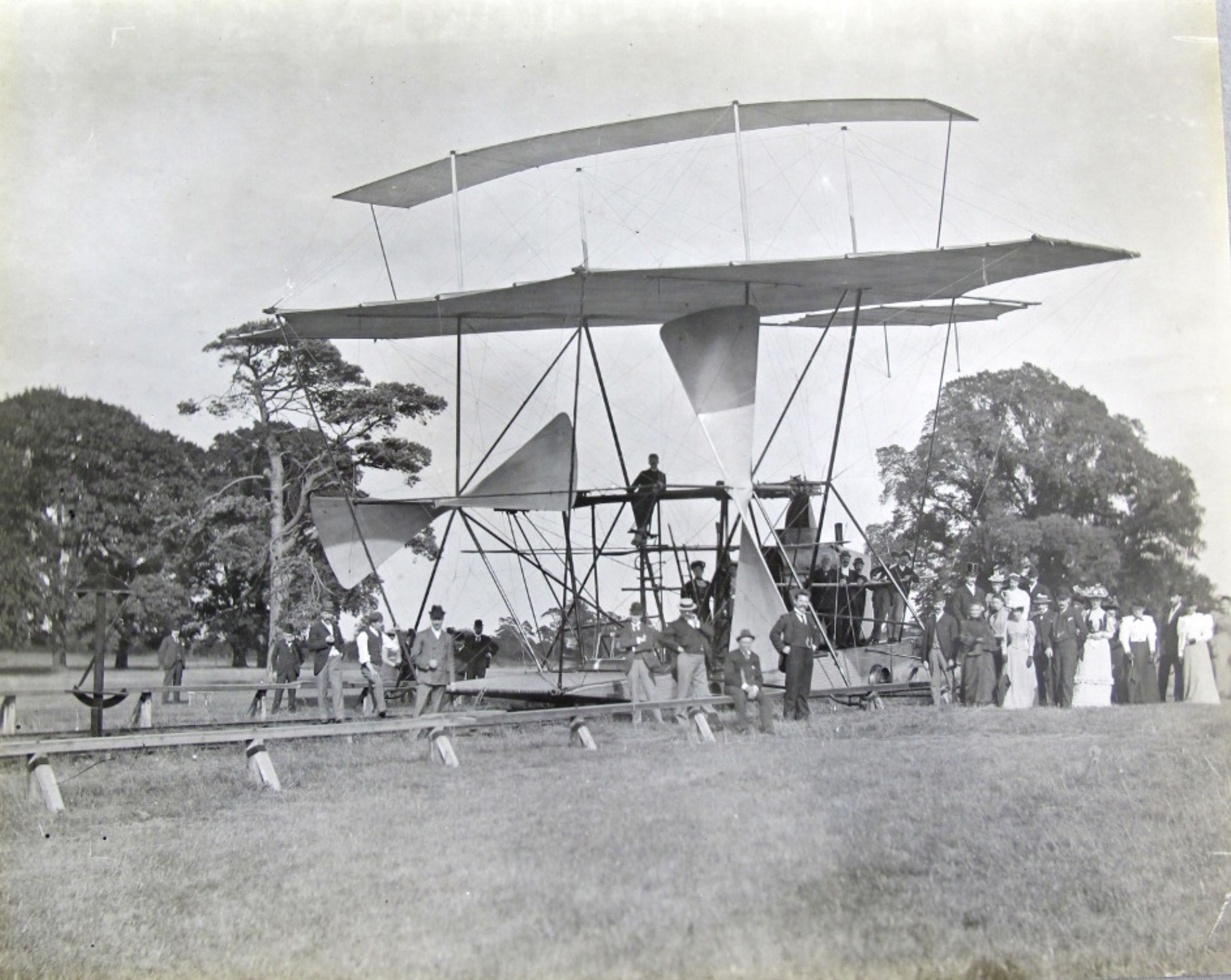 This is a photograph of Hiram Maxim's massive flying machine, with propellers eighteen feet long and wings more than twice as long. The people in the photograph are dwarfed by the machine, which never flew. The Wright brothers flyer was tiny by comparison.